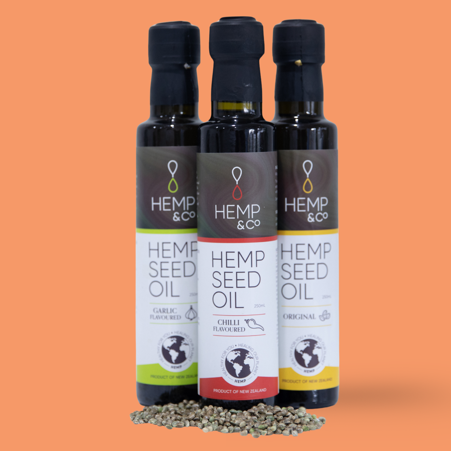 Three bottles of Hemp & Co hemp seed oil on an orange background