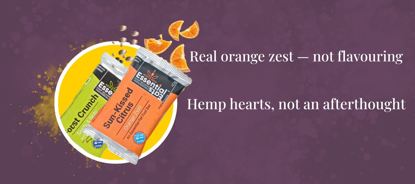 Two packages of 'Essential Eats' snacks on a purple background with text about orange zest and hemp hearts