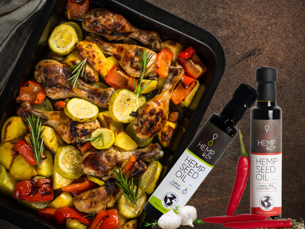 Roasted vegetables with a bottle of Hemp Seed Oil on a dark surface