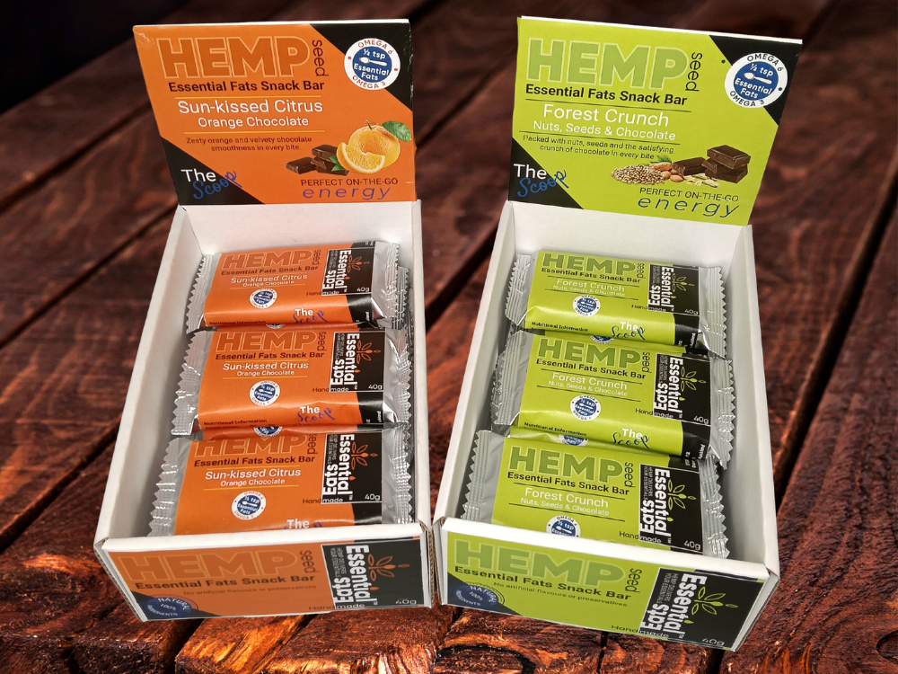Two boxes of Hemp essential fats snack bars on a wooden surface